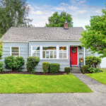 Photo of single family home with mature trees and green lawn